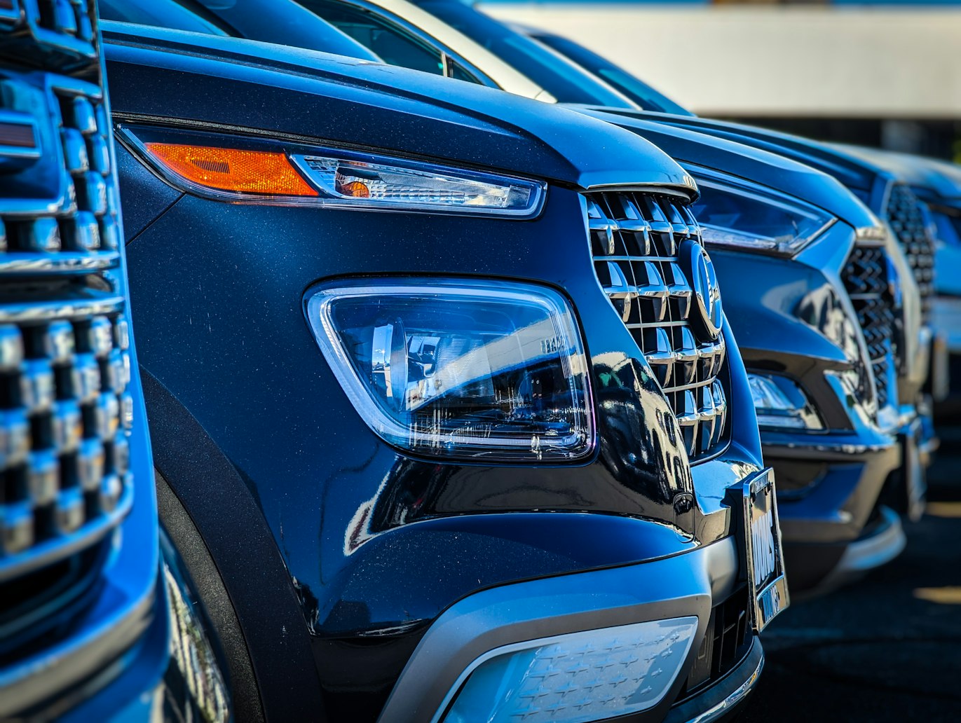 Row of blue SUVs parked nose to nose