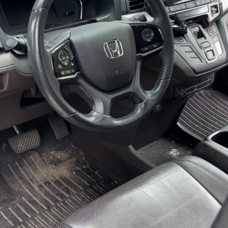 Honda Odyssey front cabin with dirty floor mats before an interior detail