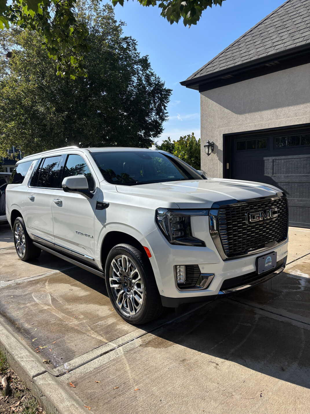 White GMC Yukon in a customer's driveway after an interior and exterior detail