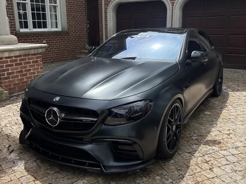 Matte black Mercedes-AMG sedan parked on a paver driveway after a detail