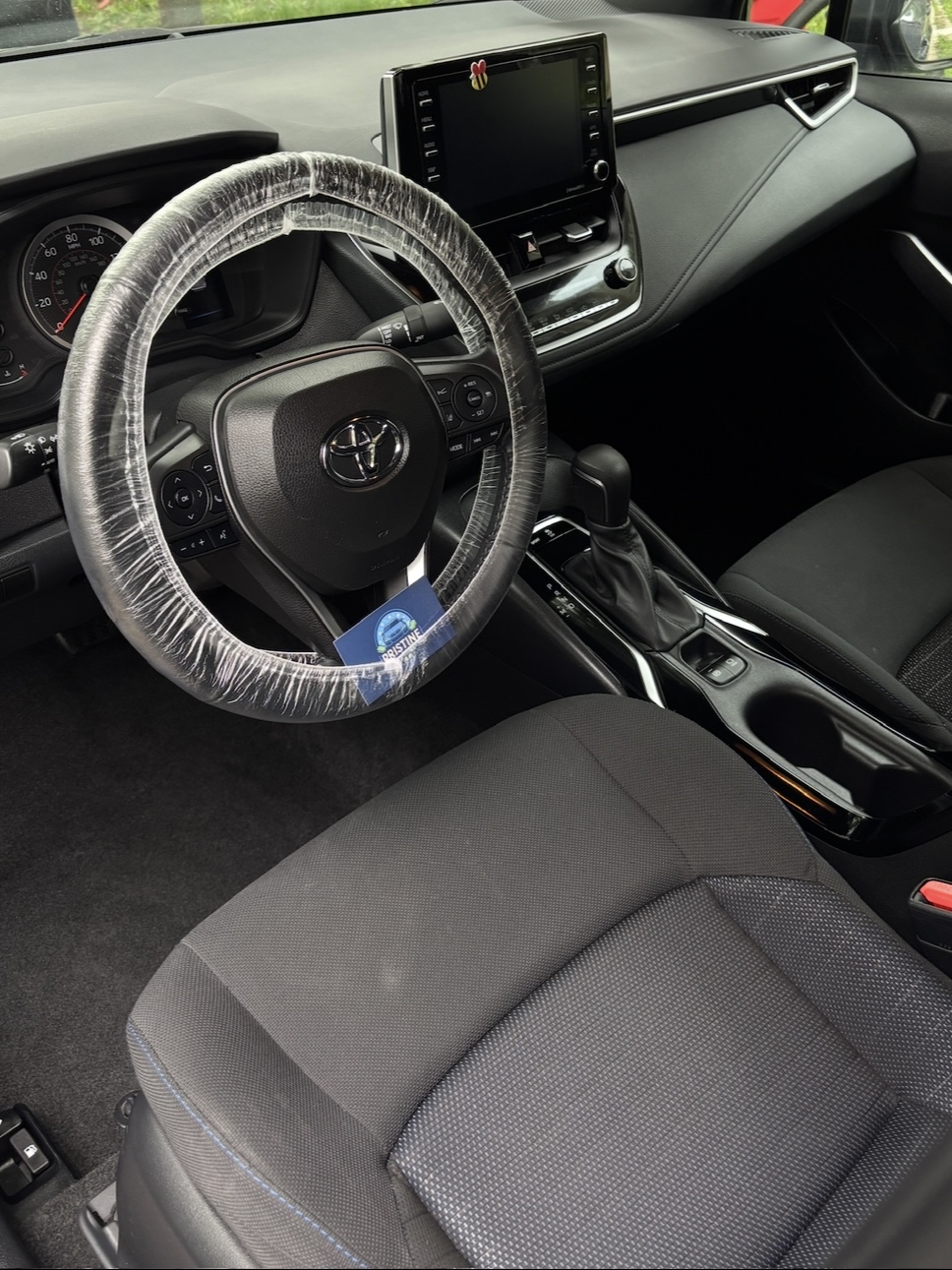Car odor removal near Arlington Heights, IL: a Toyota interior after an interior detail, steering wheel wrapped in a protective cover