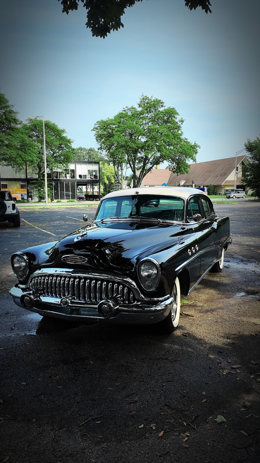 Classic black Buick sedan with a chrome grille and white roof parked after a detail