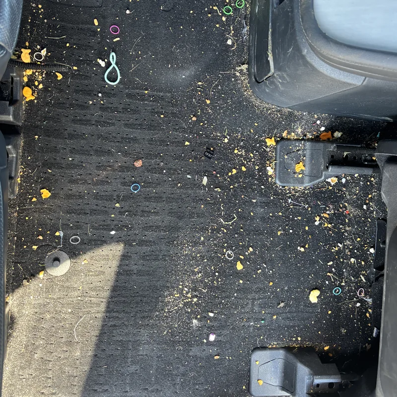 Back seat floor carpet with crumbs and dirt before interior car detailing, Arlington Heights