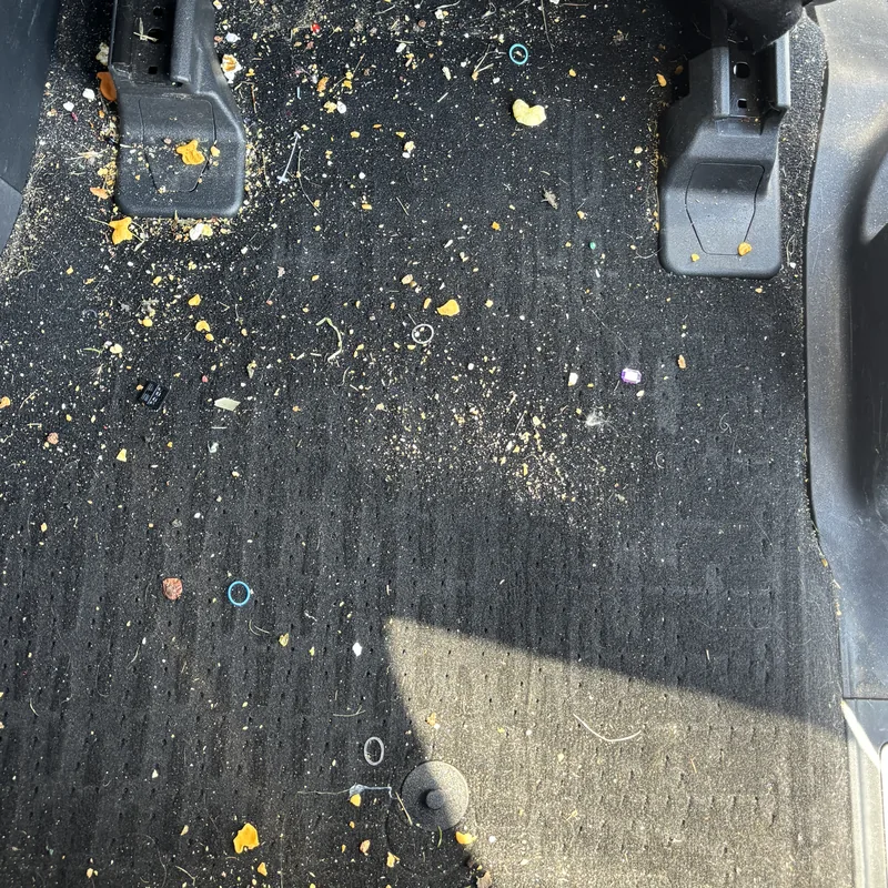 Carpet behind the front seat with crumbs and dirt before interior car detailing, Arlington Heights