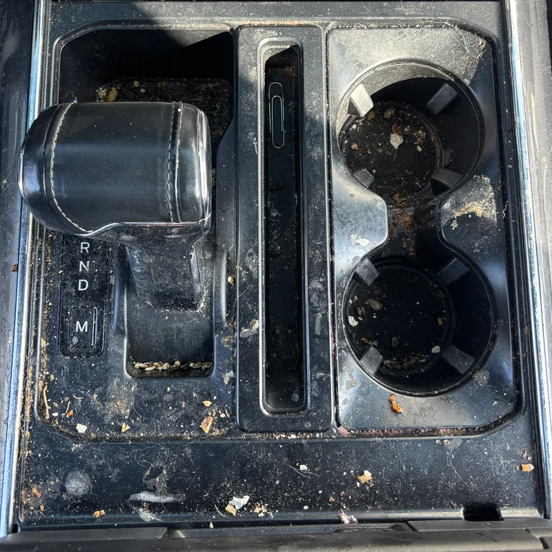 Pickup truck center console with crumbs and dirt before interior car detailing, Arlington Heights