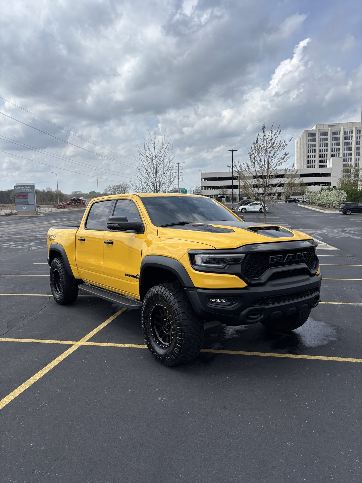 Yellow Ram TRX pickup truck parked in a business parking lot after a detail
